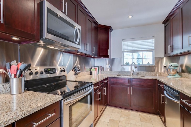 3100 Cole Ave Unit 203, Dallas, TX 75204 - kitchen with stainless steel appliances, a sink, light stone counters, reddish brown cabinets, and decorative backsplash