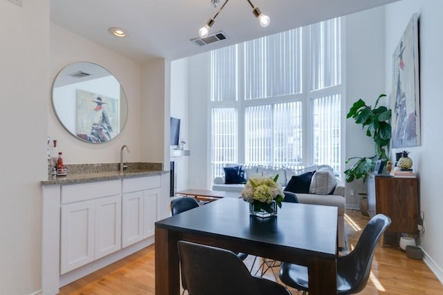 3100 Cole Ave Unit 203, Dallas, TX 75204 - dining room with light wood-style floors, wet bar, and baseboards