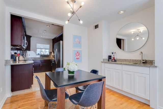 3100 Cole Ave Unit 203, Dallas, TX 75204 - dining area featuring light wood-type flooring, a chandelier, and recessed lighting