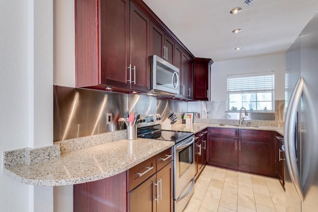 3100 Cole Ave Unit 203, Dallas, TX 75204 - kitchen with appliances with stainless steel finishes, a sink, dark brown cabinets, light stone countertops, and recessed lighting