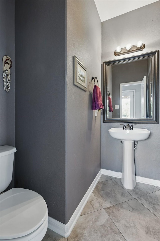 6600 Stewart Blvd, The Colony, TX 75056 - half bath featuring toilet, baseboards, a sink, and tile patterned floors