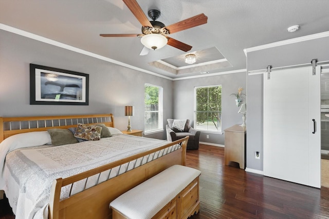 6600 Stewart Blvd, The Colony, TX 75056 - bedroom featuring a barn door, ornamental molding, dark wood-style floors, baseboards, and a tray ceiling