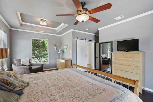 6600 Stewart Blvd, The Colony, TX 75056 - bedroom featuring a barn door, baseboards, wood finished floors, crown molding, and ceiling fan