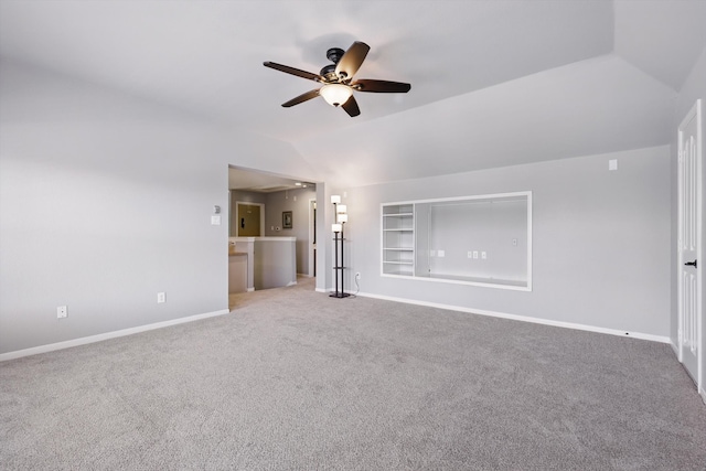 6600 Stewart Blvd, The Colony, TX 75056 - unfurnished living room featuring a ceiling fan, carpet flooring, vaulted ceiling, baseboards, and built in shelves