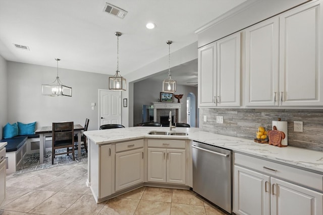 6600 Stewart Blvd, The Colony, TX 75056 - kitchen featuring dishwasher, a peninsula, backsplash, a sink, and light stone counters