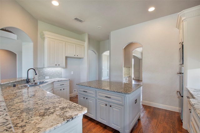 188 Las Colinas Trl, Cross Roads, TX 76227 - kitchen featuring a sink, light stone counters, tasteful backsplash, arched walkways, and recessed lighting