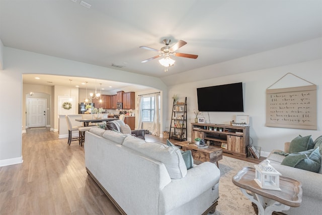 816 Kinghaven Dr, Little Elm, TX 75068 - living area with arched walkways, baseboards, light wood finished floors, ceiling fan, and a chandelier