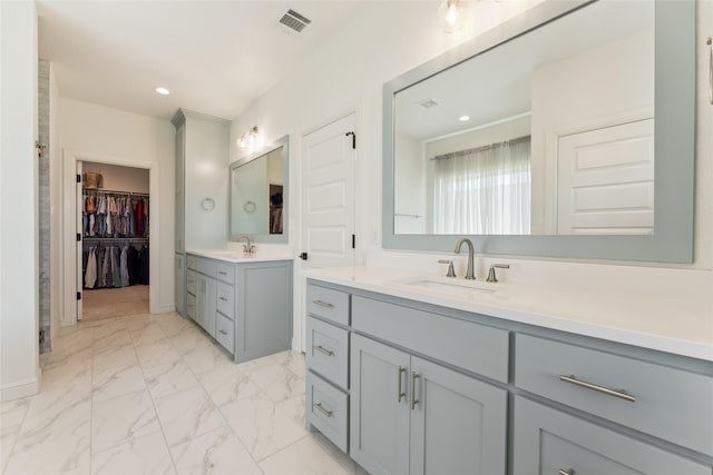 959 County Road 1300, Bridgeport, TX 76426 - bathroom featuring two vanities, marble finish flooring, recessed lighting, a walk in closet, and baseboards