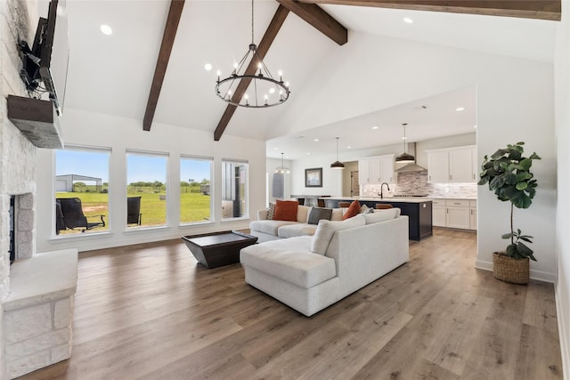 959 County Road 1300, Bridgeport, TX 76426 - living area featuring high vaulted ceiling, beam ceiling, a chandelier, light wood-style floors, and a stone fireplace