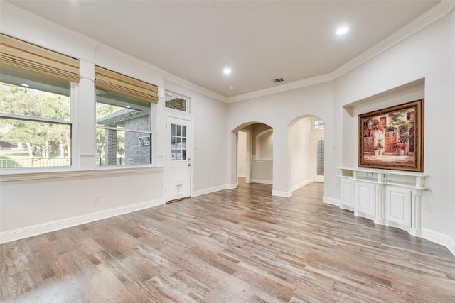 2132 Portwood Way, Fort Worth, TX 76179 - spare room featuring light wood-style floors, ornamental molding, arched walkways, baseboards, and recessed lighting