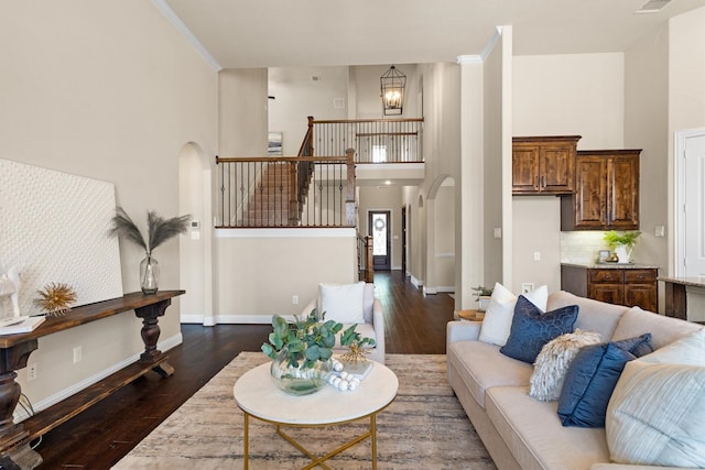 2886 Nottingham Dr, Trophy Club, TX 76262 - living room featuring a towering ceiling, dark wood finished floors, arched walkways, a chandelier, and baseboards