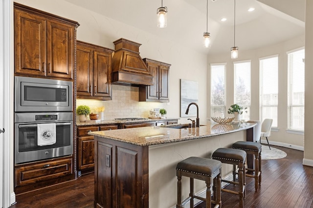 2886 Nottingham Dr, Trophy Club, TX 76262 - kitchen featuring stainless steel appliances, a sink, light stone countertops, tasteful backsplash, and dark wood-style floors
