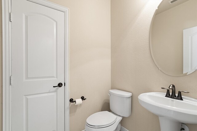 2886 Nottingham Dr, Trophy Club, TX 76262 - half bath featuring a sink, toilet, and baseboards