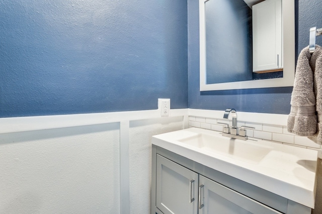 3907 Throckmorton St Unit 4, Dallas, TX 75219 - bathroom with vanity, a textured wall, and a wainscoted wall