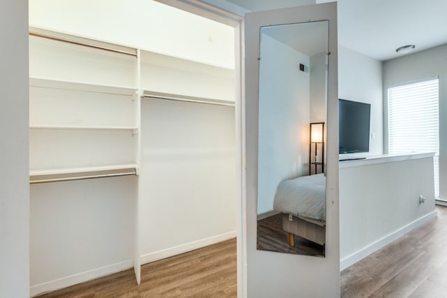 3907 Throckmorton St Unit 4, Dallas, TX 75219 - bedroom featuring wood finished floors, a closet, and baseboards