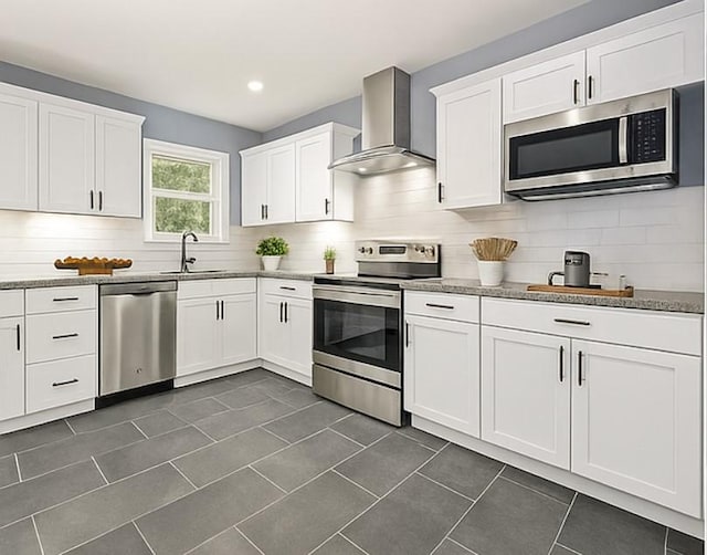 3124 Crest Ridge Dr, Dallas, TX 75228 - kitchen featuring stainless steel appliances, wall chimney range hood, a sink, decorative backsplash, and white cabinetry