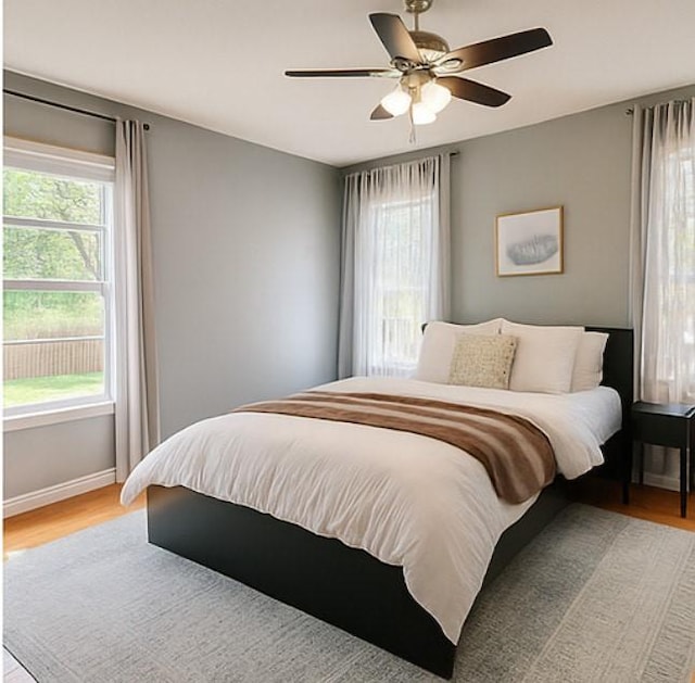 3124 Crest Ridge Dr, Dallas, TX 75228 - bedroom featuring multiple windows, light wood-style floors, and baseboards