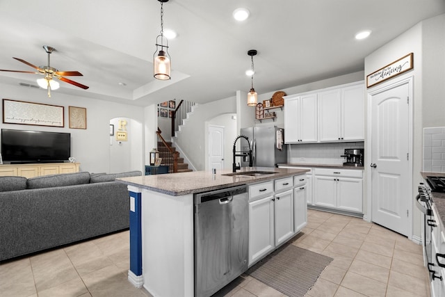501 Bird Creek Dr, Little Elm, TX 75068 - kitchen featuring stainless steel appliances, tasteful backsplash, a ceiling fan, open floor plan, and arched walkways