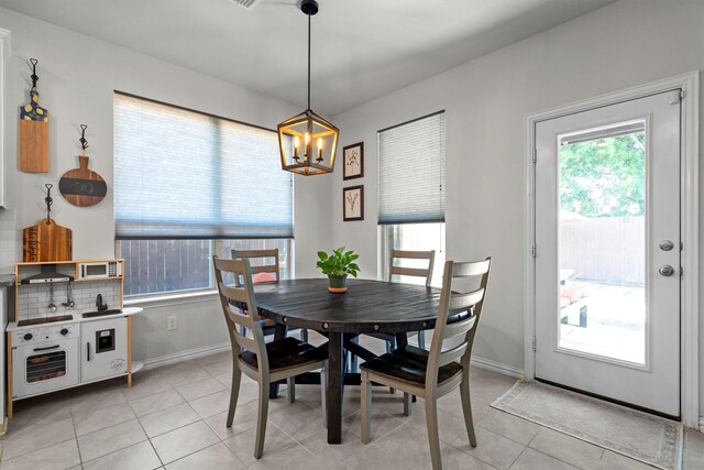 501 Bird Creek Dr, Little Elm, TX 75068 - dining space featuring a chandelier, light tile patterned floors, and baseboards