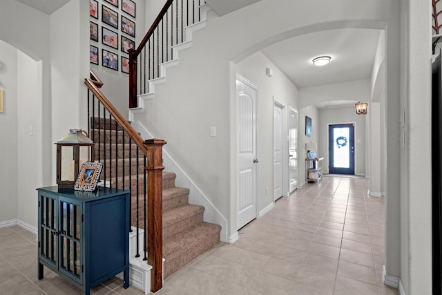 501 Bird Creek Dr, Little Elm, TX 75068 - foyer with arched walkways, light tile patterned flooring, baseboards, and stairway