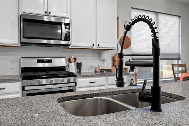 501 Bird Creek Dr, Little Elm, TX 75068 - kitchen with stainless steel appliances, white cabinets, decorative backsplash, and light stone counters