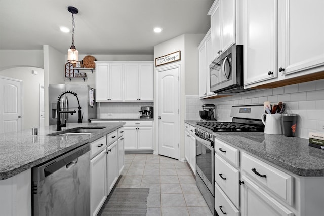 501 Bird Creek Dr, Little Elm, TX 75068 - kitchen with appliances with stainless steel finishes, decorative backsplash, white cabinetry, hanging light fixtures, and light tile patterned flooring