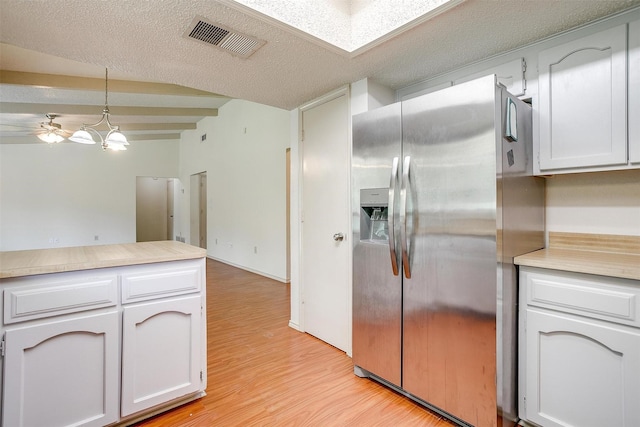 6436 Meadowlark Ln E, Watauga, TX 76148 - kitchen with stainless steel refrigerator with ice dispenser, light wood-style floors, light countertops, decorative light fixtures, and a textured ceiling