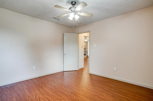 6436 Meadowlark Ln E, Watauga, TX 76148 - unfurnished room featuring a ceiling fan, wood finished floors, baseboards, and a textured ceiling