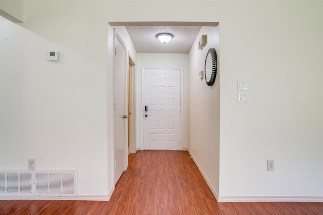 6436 Meadowlark Ln E, Watauga, TX 76148 - hallway with wood finished floors, a textured ceiling, and baseboards