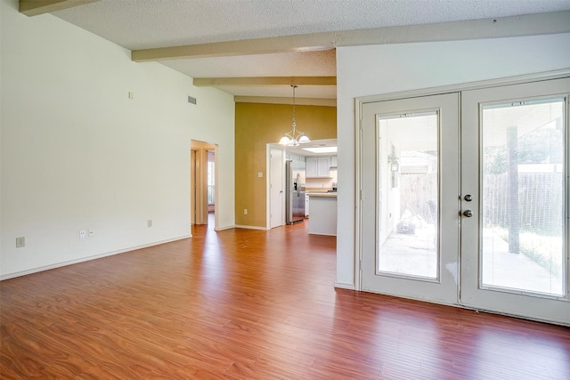 6436 Meadowlark Ln E, Watauga, TX 76148 - unfurnished living room featuring a chandelier, wood finished floors, french doors, plenty of natural light, and a textured ceiling