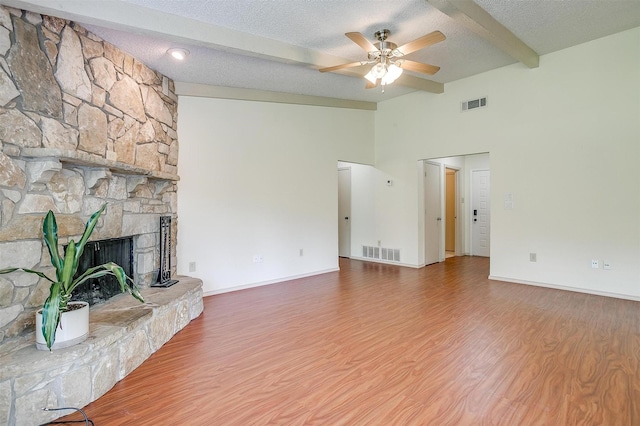 6436 Meadowlark Ln E, Watauga, TX 76148 - unfurnished living room featuring ceiling fan, wood finished floors, beamed ceiling, a textured ceiling, and high vaulted ceiling