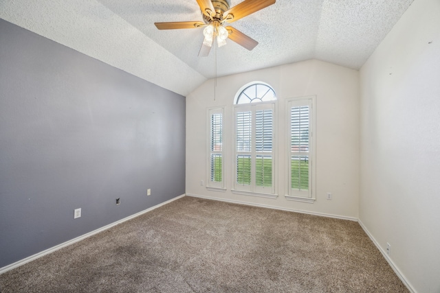 empty room with lofted ceiling, a textured ceiling, carpet, a ceiling fan, and baseboards