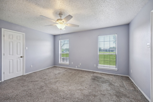 carpeted empty room with ceiling fan, a textured ceiling, and baseboards