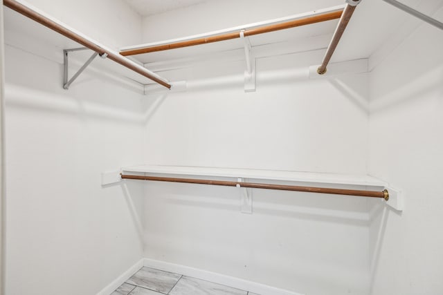 spacious closet with light marble finish floors