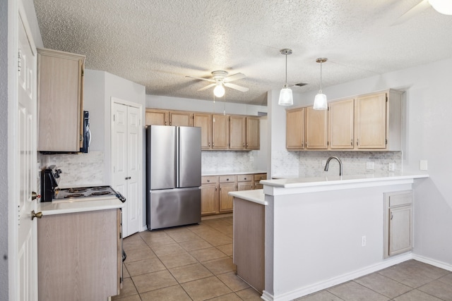 kitchen featuring freestanding refrigerator, ceiling fan, a peninsula, electric range oven, and light tile patterned flooring