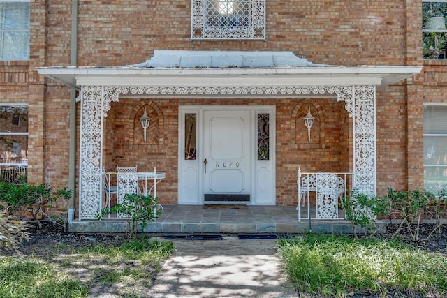 6070 Averill Way Unit A, Dallas, TX 75225 - view of exterior entry with covered porch and brick siding