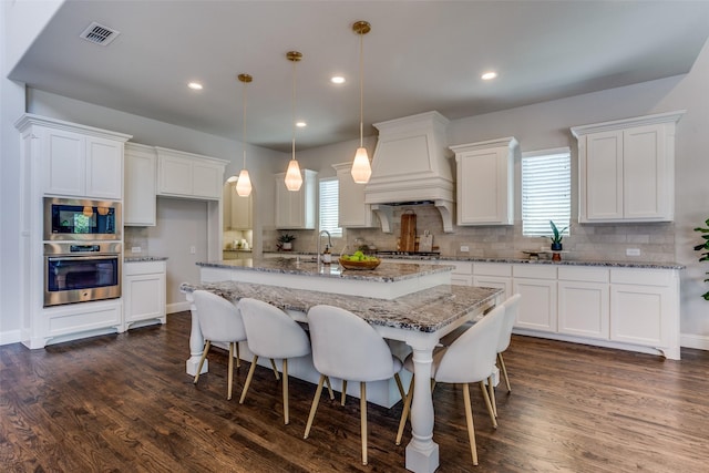 2205 Grafton Ln, Mckinney, TX 75071 - kitchen with appliances with stainless steel finishes, custom exhaust hood, backsplash, plenty of natural light, and recessed lighting