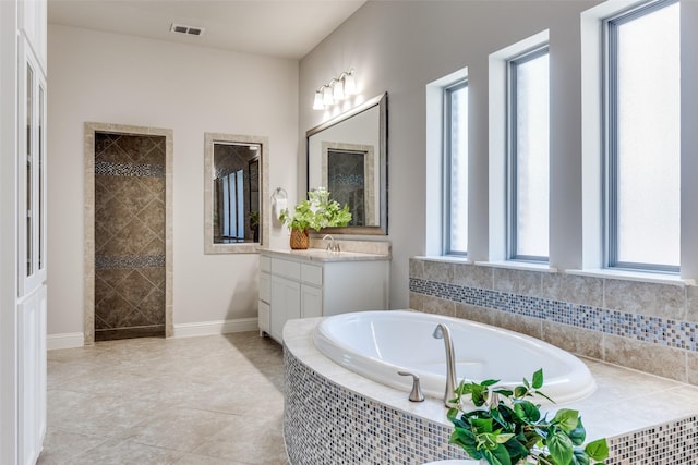 2205 Grafton Ln, Mckinney, TX 75071 - full bath featuring vanity, a garden tub, a tile shower, baseboards, and tile patterned flooring