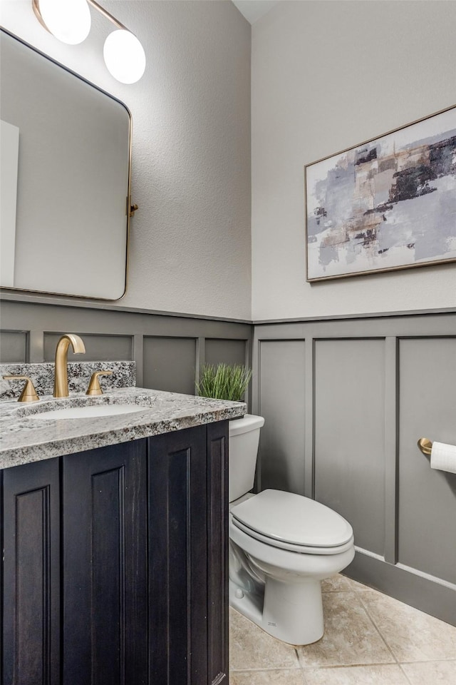 2205 Grafton Ln, Mckinney, TX 75071 - bathroom with a decorative wall, tile patterned flooring, toilet, vanity, and a wainscoted wall