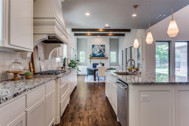 2205 Grafton Ln, Mckinney, TX 75071 - kitchen with a sink, stainless steel appliances, dark wood-style floors, tasteful backsplash, and a large fireplace