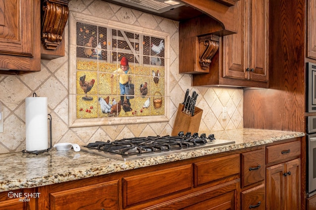 4549 Coyote Run, Abilene, TX 79602 - kitchen featuring appliances with stainless steel finishes, tasteful backsplash, light stone countertops, and brown cabinets