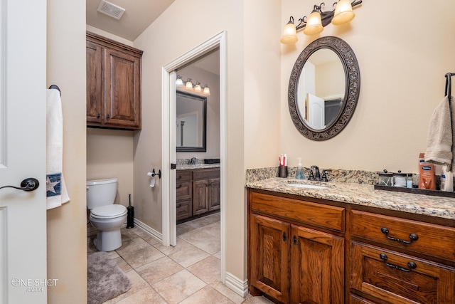 4549 Coyote Run, Abilene, TX 79602 - bathroom with toilet, vanity, baseboards, and tile patterned flooring