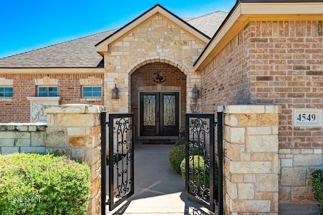 4549 Coyote Run, Abilene, TX 79602 - entrance to property featuring roof with shingles, brick siding, a gate, and stone siding