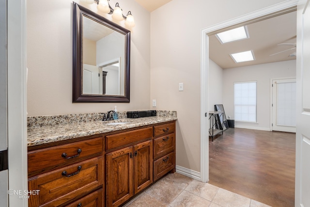 4549 Coyote Run, Abilene, TX 79602 - bathroom with baseboards, vanity, and a skylight