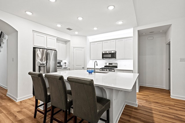 3952 Oak Creek Cir, Denison, TX 75020 - kitchen with stainless steel appliances, a sink, wood finished floors, baseboards, and recessed lighting