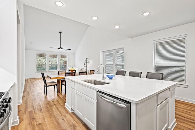 3952 Oak Creek Cir, Denison, TX 75020 - kitchen featuring stainless steel appliances, a sink, light wood finished floors, ceiling fan, and an island with sink