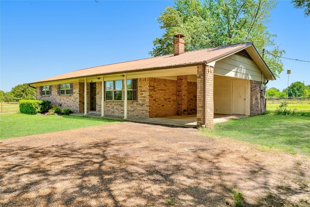 125 Harrison, Detroit, TX 75436 - ranch-style home with driveway, brick siding, a chimney, metal roof, and a carport
