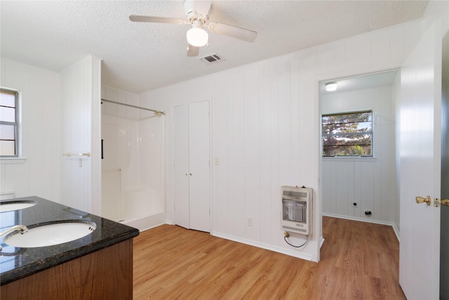 125 Harrison, Detroit, TX 75436 - full bath featuring heating unit, wood finished floors, a shower, a textured ceiling, and ceiling fan