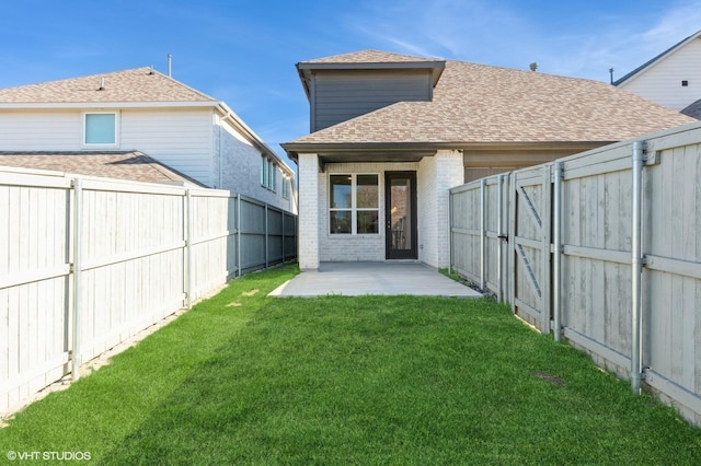 rear view of property featuring a patio, brick siding, a shingled roof, and a gate