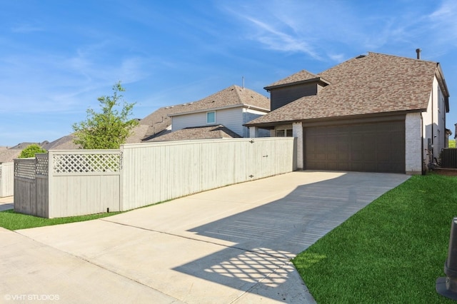 view of property exterior with driveway, fence, a garage, and roof with shingles